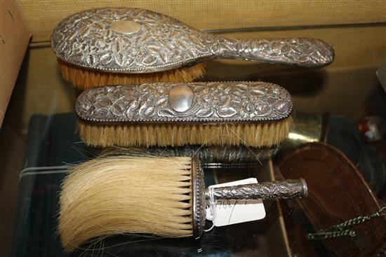 Three late Victorian repousse silver mounted dressing table brushes,